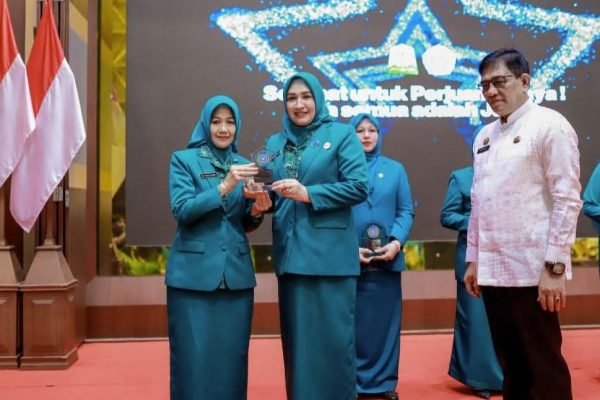 Ketua TP-PKK Aceh, Ny. Marlina Muzakir Manaf menyerahkan piagam penghargaan kepada Ketua TP-PKK Aceh Tamiang, Ny. Yuyun Armia, Kamis (17/7). Foto: GPriority/Humas Protokol Aceh Tamiang