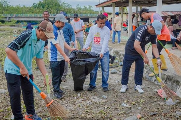Bupati Ubaid Yakub, saat menyapu rumput dan sampah di depan Pasar Kota Maba. Foto: GPriority/Riftan