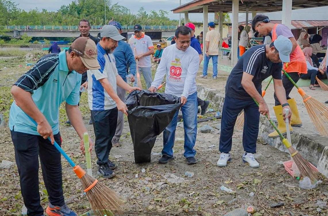 Bupati Ubaid Yakub, saat menyapu rumput dan sampah di depan Pasar Kota Maba. Foto: GPriority/Riftan