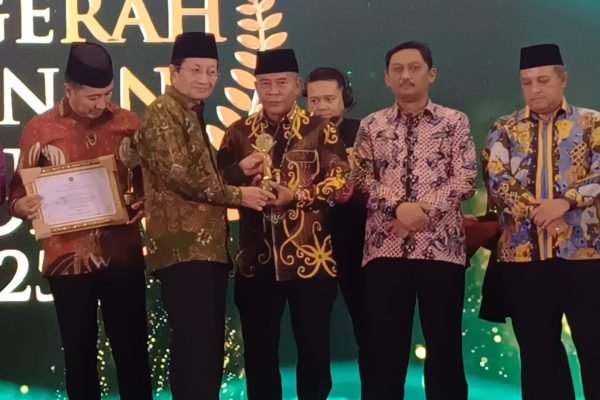Menteri Agama menyerahkan penghargaan kepada Gubernur Kalimantan Utara dalam ajang Anugerah Layanan KUA 2025, Jumat (12/12). Foto: GPriority/Dimas A Putra