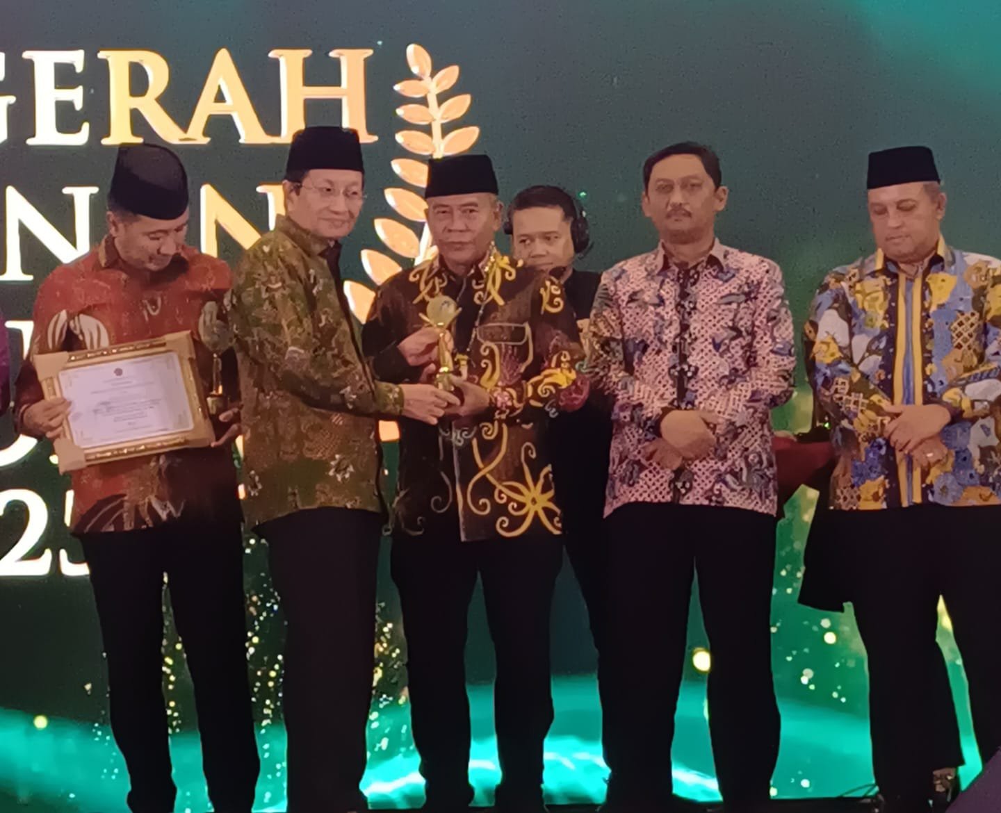 Menteri Agama menyerahkan penghargaan kepada Gubernur Kalimantan Utara dalam ajang Anugerah Layanan KUA 2025, Jumat (12/12). Foto: GPriority/Dimas A Putra