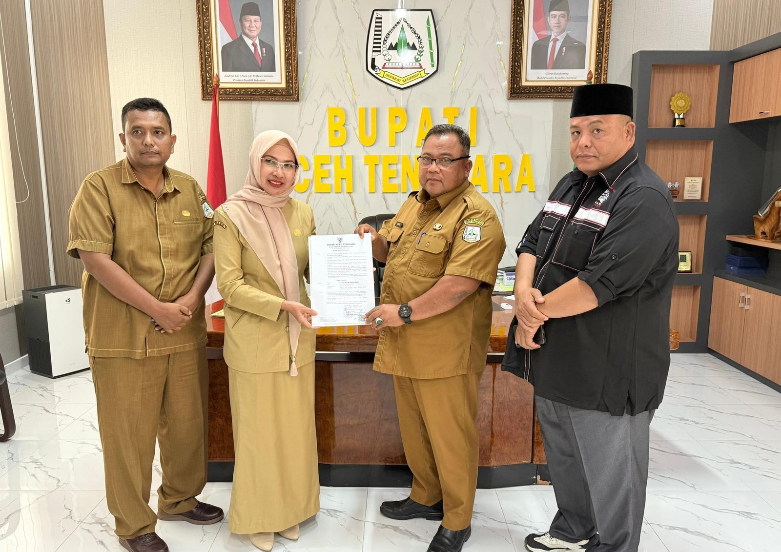 Sekda Aceh Tenggara Yusrizal didampingi Kepala BKPSDM, Abdul Syafaruddin dan Ketua MAA, Kasri Selian menyerahkan SK Plt Kadis DPPKB Aceh Tenggara kepada dr. Nurlela, Sp.PA. (Dok. BKPSDM Aceh Tenggara).