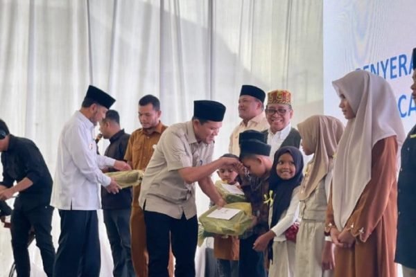 Wakil Gubernur Aceh, Fadhlullah saat memberikan santunan kepada anak yatim disela penyerahan bantuan rumah rusak tahap II korban banjir dan longsor Aceh. Foto: humas Pemprov Aceh.
